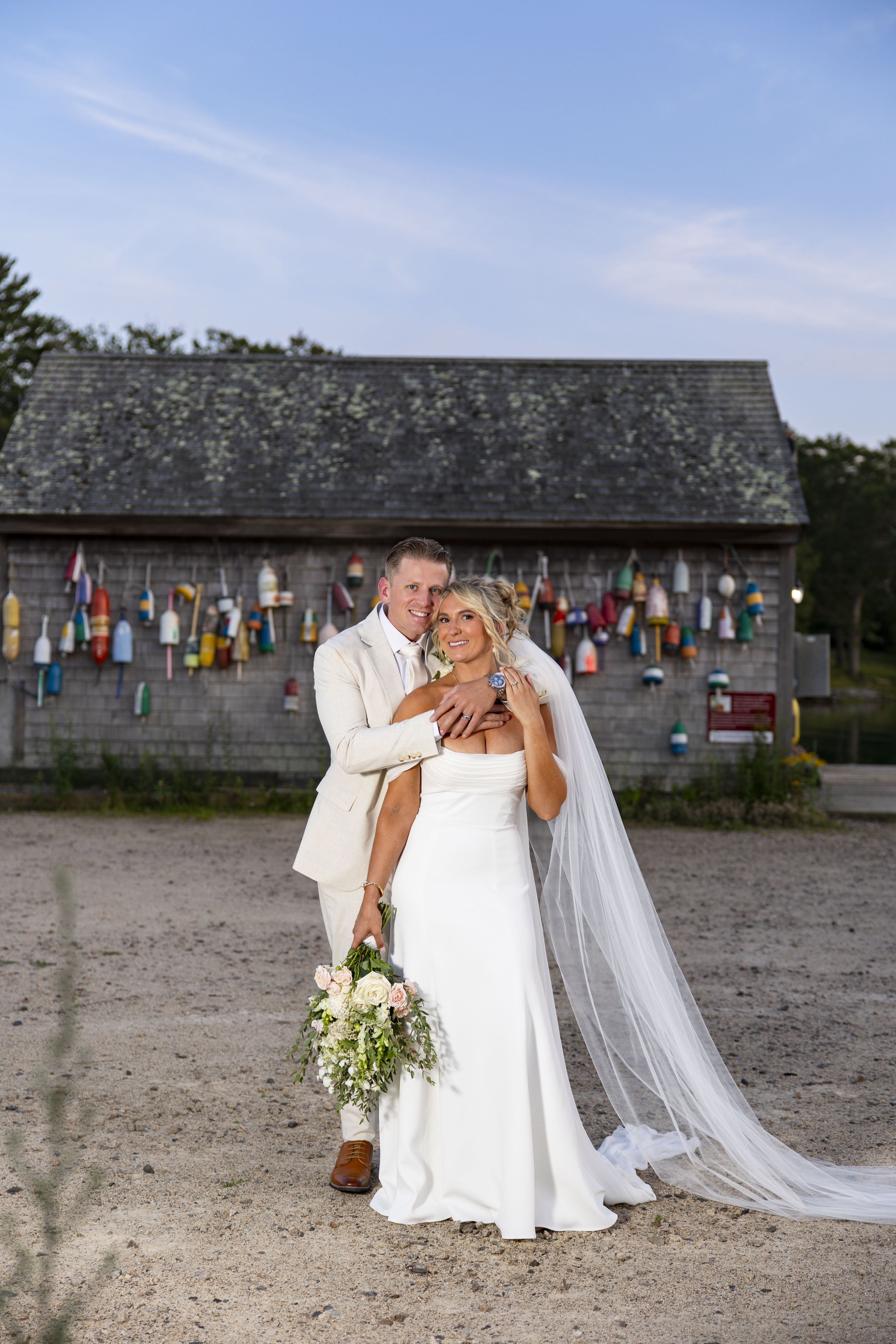 Maine coastal wedding couple by a buoy-covered shack — Studio44 North